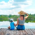 "बच्चों के साथ झील के किनारे मछली पकड़ने का आनंद लेता एक परिवार।"